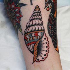 a close up of a person's foot with a tattoo on it and an image of a sea shell