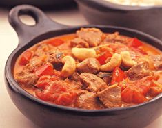 a bowl filled with meat and vegetables on top of a table