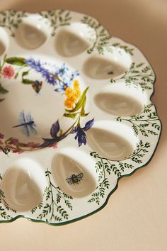 a white plate with flowers and bugs on it