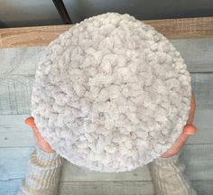 a person with their hands on the top of a large white object in front of a wooden wall