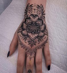 a woman's hand with a flower tattoo on it