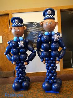 two balloons shaped like police officers standing next to each other