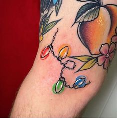 a close up of a person's arm with tattoos on it and flowers around the wrist