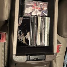 the inside of a car with several cds and cassette's in the back seat