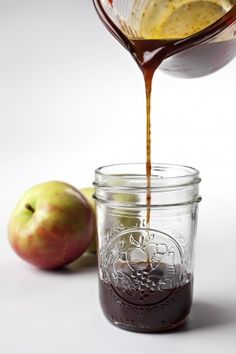 an apple cider being poured into a mason jar filled with caramel and chocolate