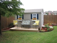 a small backyard with lawn furniture and flowers