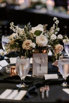 Low Floral Arrangement with Mixed White Flowers, Roses, and Greenery | Elegant Black Table Decor with Mercury Candle Votives Black Floral Centerpiece Wedding, Black Tie Wedding Reception Centerpieces, Gold Black Centerpieces, Black And White Flower Centerpieces, Black And Gold Floral Centerpieces, Black And Gold Flower Arrangements, Black Table White Flowers, Black White Gold Floral Centerpieces, Black Vase White Flower Centerpiece