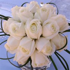 a bouquet of white roses in a clear vase