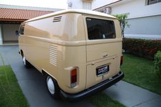 an old yellow van parked in front of a house