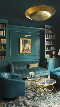 a living room filled with furniture and bookshelves next to a painting on the wall