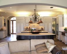 a large open concept kitchen and living room with an archway leading to the dining area