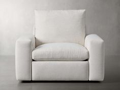 a white chair sitting on top of a floor next to a gray wall and wooden floors