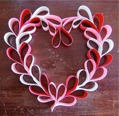 a heart made out of paper sitting on top of a wooden table