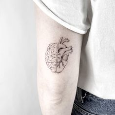 a woman's left arm with a black and white heart tattoo on it