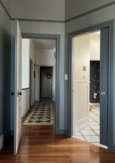 Erin Zubot’s hallway painted blue with contrasting blue trims. Blue Trim Living Room, Cream Walls Blue Trim, Dark Trim Light Floors, Moody Hallway Paint Colors, Blue Walls And Trim, Contrast Trim Bedroom, Color Drenched Hallway, Trim Hallway, Blue Trim Interior