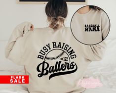 "Baseball Mama Sweatshirt, Busy Raising Ballers, Somebodys Loud Mama, Baseball Crewneck , Baseball Mom Shirt, Game Day Mom Shirt, Sport Mom 📋 HOW TO ORDER: 1. Select the size 2. Select the color 3. Select the quantity 4. Add personalization if required 5.Add to Cart (\"buy now\" will take you directly to checkout and \"add to cart\" will allow you to continue shopping with us) 6. Submit order (Shipping will automatically be combined for you) Always FREE SHIPPING on orders of $35 or more 👚G A R Basketball Shirt Designs, Game Day Basketball, Busy Raising Ballers, Raising Ballers, Basketball Mom Shirts, Basketball Hoodie, Basketball Sweatshirts, Winter Projects, Personalized Basketball