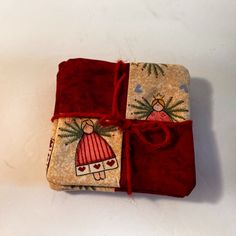 two red and beige christmas wrappings tied up on top of each other with decorations