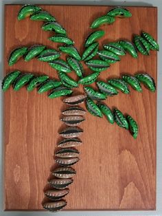 a palm tree made out of green leaves on a wooden board with screwdrivers