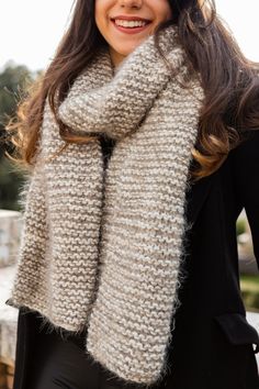 a woman wearing a knitted scarf and smiling