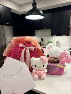 a hello kitty gift set on a kitchen counter with pink flowers in a basket and stuffed animals