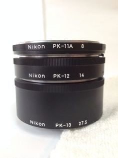 three nikon pk - 12 lenses sitting on top of each other in front of a white towel