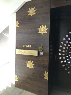 a wooden door with gold leaves on it and a name plate that reads b - 601