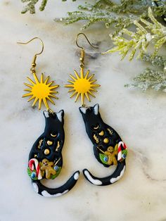 black cat earrings with yellow sun on top