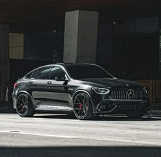 a black mercedes suv parked in front of a building