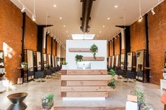 the interior of a hair salon with wooden stairs and potted plants on each side