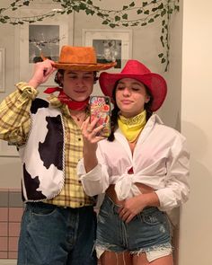 two people dressed up in costumes standing next to each other and taking a selfie