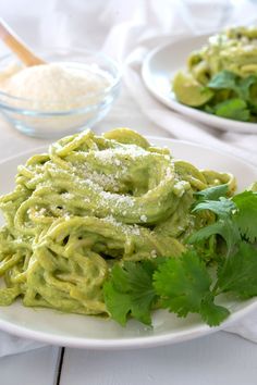 mexican green spaghetti on a white plate with cilantro and parsley garnish