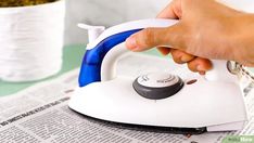 a person is using an iron on top of a newspaper with a potted plant in the background