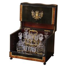 an old fashioned wooden case with many glass items in it