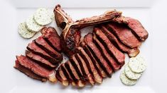 a plate with steak, potatoes and crackers on it