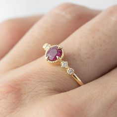 This 14k gold uniquely designed Ruby ring will make the perfect alternative engagement ring for the non-traditional brides. This unique ring has a milgrain finish on the frame around the Ruby to give a vintage feel. Attached to the Ruby are two star-shaped settings with diamonds adding uniqueness and sparkle to the ring. Ruby is a very unique stone with many different meanings. It is the birthstone of July. 4.5mm ruby 0.04ctw G color SI clarity accent diamonds Band width: approx. 1.3mm Low profi Dainty Ruby Ring With Round Cut, Ruby Ring With Bezel Setting, Round Cut, Bezel-set Round Cut Ruby Ring, Yellow Gold Birthstone Ring With Synthetic Ruby For Wedding, Yellow Gold Birthstone Ring With Lab-created Ruby For Wedding, Yellow Gold Wedding Birthstone Ring With Lab-created Ruby, Yellow Gold Wedding Ring With Lab-created Ruby Birthstone, Heirloom Style Ruby Birthstone Ring For Promise, Ruby Bezel Setting Ring For Anniversary