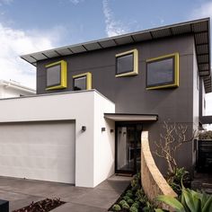 a modern house with yellow trim and windows