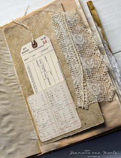 an old book with lace and tags on it