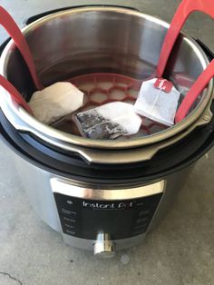 a crock pot with two red spatulas in it