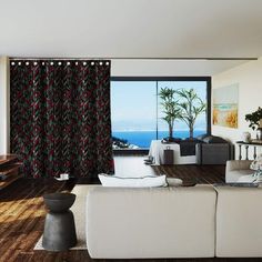 a living room filled with furniture and a large window covered in curtains next to a wooden floor