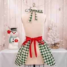 This festive Green Gingham apron is a fun addition to your holiday baking this year! The perfect apron to create more fun this holiday season! This apron is with a red ric rac details, gingham green design and a pretty red gingerbread printed mini apron. This apron is cute and functional. Made to wash and wear for year to come. Women's sizes- SM/MED fits 0-12 LG/XL fits 12-24 This beautiful Apron has these features: Retro style designed to flatter!! Made with 100% cotton fabric Machine washable Gingham Christmas, Gingham Apron, Red Apron, Christmas Apron, Red Poinsettia, Christmas Aprons, Green Gingham, Ric Rac, Holiday Baking