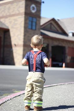 a little boy that is standing in the street with a tie on his shirt and pants