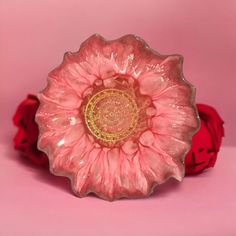 a pink flower shaped bowl sitting on top of a table