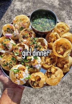 a person holding a platter full of food with the words girl dinner on it