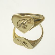 The heart signet ring is a classic, and this one is personalized with an inset monogram. This item is engravable with text or monogram of your choice at no extra cost. The initals are engraved onto the ring and embedded in the 3D model for a flawless embossed finish. You may choose to customize this ring with different images, letters or words. A render of your custom design will be sent to you before production. Heart width: 14mm Heart height: 11mm A few notes about our gold: - Though we do not Classic Heart-shaped Signet Ring For Wedding, Antique Initial Ring In 14k Gold, Antique Signet Ring With Initials For Formal Events, Heirloom Engraved Heart Ring, Classic Jewelry For Valentine's Day, Classic Silver Engraved Ring For Valentine's Day, Antique Engraved Ring With Initials For Formal Occasions, Classic Oval Heart Ring In White Gold, Classic Oval White Gold Heart Ring