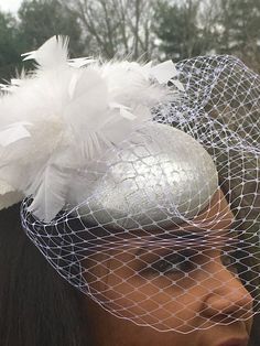 Perfect for the Bride!Silver metallic leather with a crocodile embossed pattern.Small button fascinator trimmed with a handmade cluster of white feathers made to give height and interest to this special piece.The white veiling and white velvet leaves give the finished look of mystery and beauty.This one has sold ... Allow 2 to 3 weeks for delivery of a special order. Glamorous Silver Bridal Accessories For Evening, Elegant Silver Fascinator For Wedding, Silver Evening Headpiece For Royal Ascot, Silver Headpiece For Evening At Royal Ascot, Elegant Silver Wedding Fascinator, White Feathered Fascinator For Wedding, Silver Fascinator For Kentucky Derby Party, Silver Fascinator For Kentucky Derby Wedding, Silver Evening Fascinator For Kentucky Derby