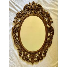 an ornately carved mirror on a white sheet