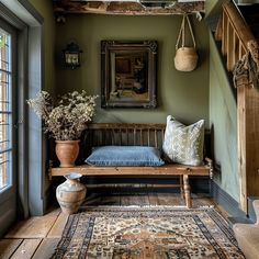 a wooden bench sitting under a window next to a rug