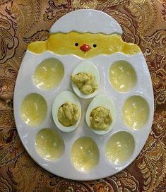 an egg tray with deviled eggs in it and a rubber ducky face on top