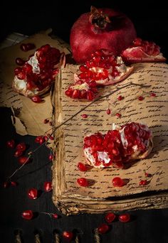 the pomegranates are on top of an old piece of paper