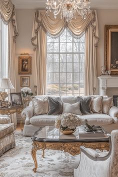 a living room filled with furniture and a chandelier above a fire place in front of a window